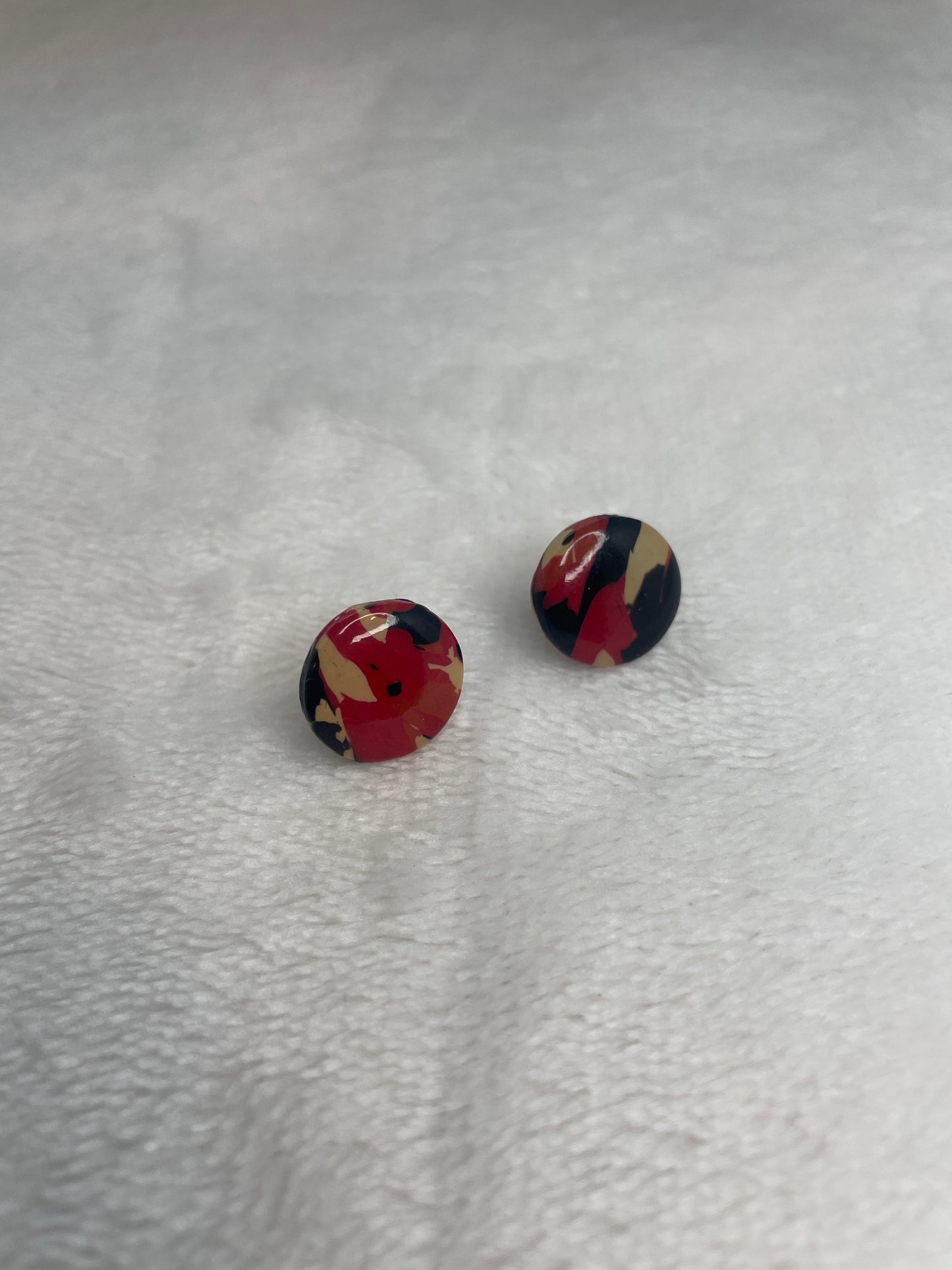 Black, red, orange, and beige marble studs